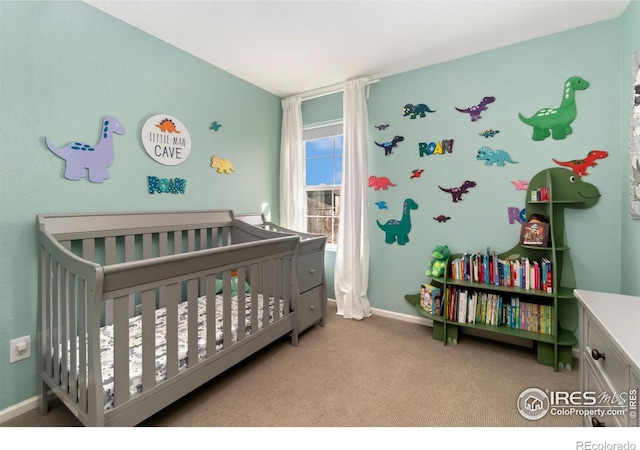 bedroom featuring baseboards, a crib, and carpet flooring