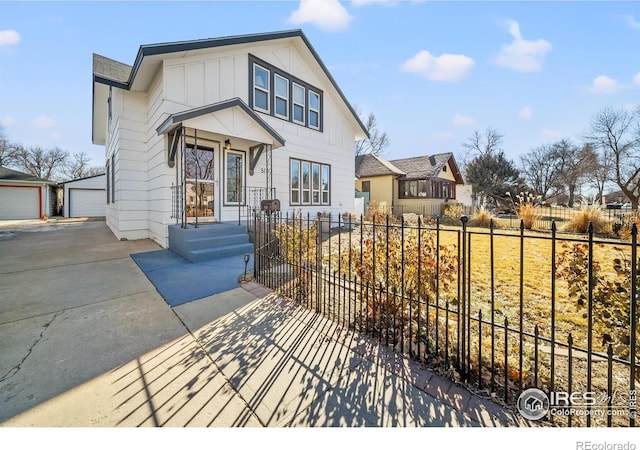 view of front of property with a fenced front yard, an outbuilding, board and batten siding, and a garage