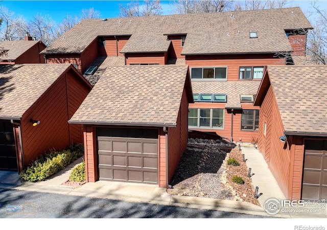 townhome / multi-family property featuring a garage and roof with shingles