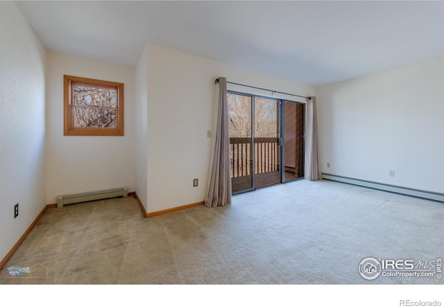 empty room featuring baseboards, baseboard heating, and carpet flooring