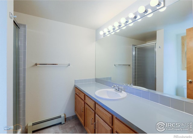 bathroom with tile patterned floors, a shower stall, vanity, and a baseboard radiator