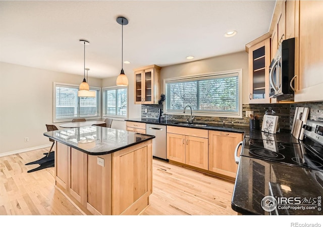 kitchen with a sink, light wood-type flooring, light brown cabinetry, and stainless steel appliances