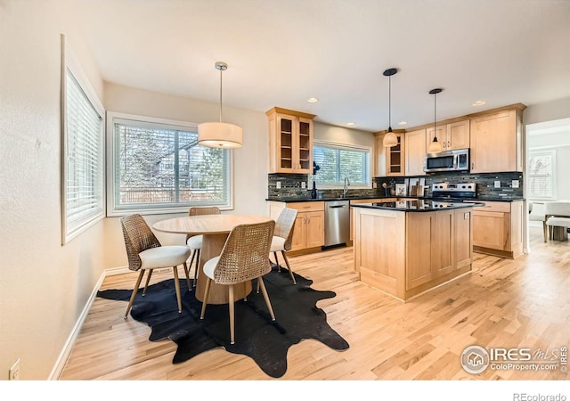 kitchen featuring dark countertops, appliances with stainless steel finishes, and light brown cabinetry