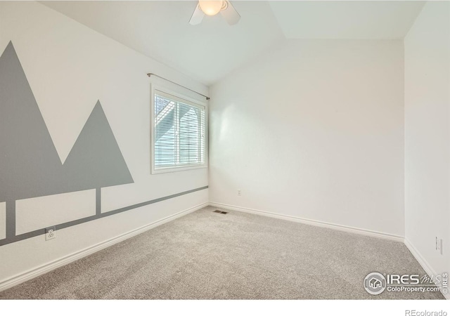 carpeted spare room featuring visible vents, ceiling fan, baseboards, and vaulted ceiling