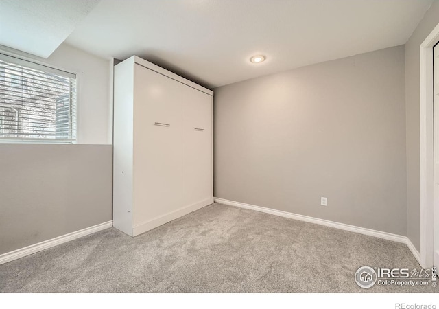 carpeted spare room featuring baseboards