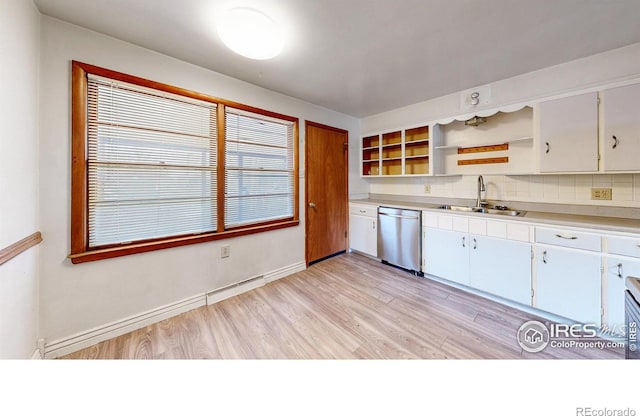 kitchen featuring a sink, open shelves, stainless steel dishwasher, light wood-style floors, and light countertops