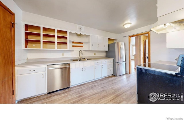 kitchen featuring a sink, light wood-type flooring, stainless steel appliances, white cabinetry, and open shelves