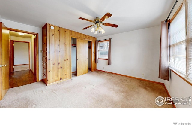 unfurnished bedroom featuring a closet, baseboards, carpet, and a ceiling fan