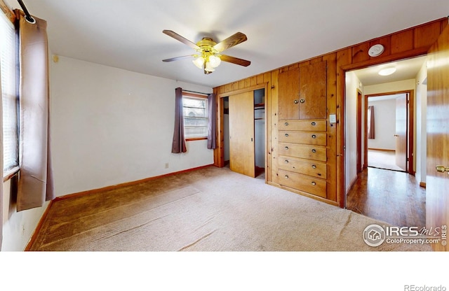 unfurnished bedroom with a ceiling fan, a closet, carpet floors, and baseboards