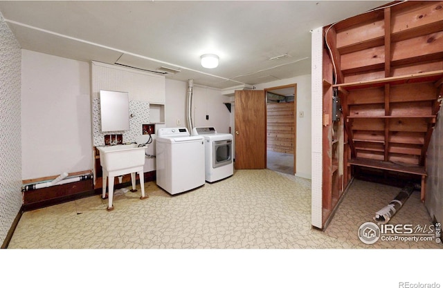 clothes washing area with washing machine and clothes dryer, laundry area, and light floors