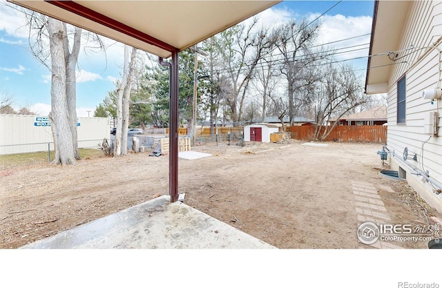 view of yard featuring an outdoor structure, a storage shed, and a fenced backyard