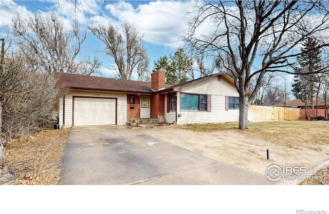 ranch-style home with driveway, fence, a garage, brick siding, and a chimney