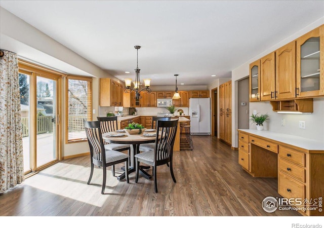 dining room featuring a notable chandelier, wood finished floors, built in desk, recessed lighting, and baseboards