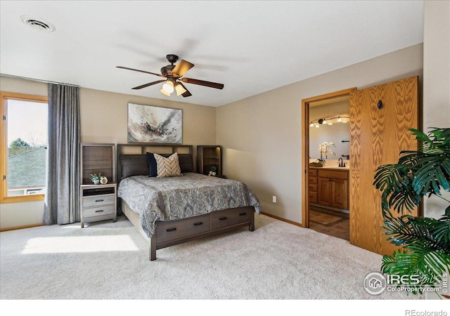 bedroom featuring carpet, visible vents, baseboards, ceiling fan, and ensuite bathroom