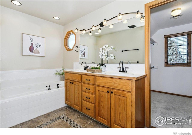 bathroom featuring double vanity, visible vents, a bath, and a sink