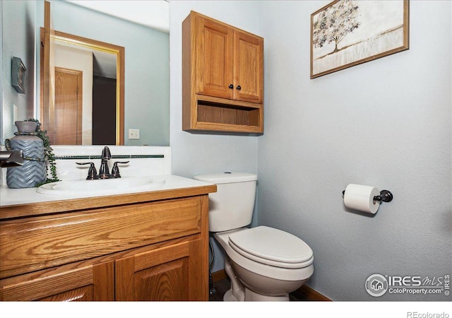 half bathroom featuring toilet and vanity