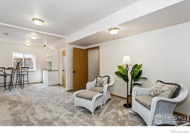 living area with visible vents, carpet, and baseboards