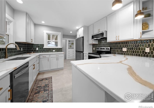 kitchen with a sink, light stone counters, plenty of natural light, and stainless steel appliances