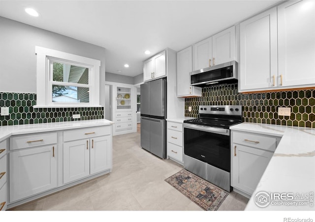 kitchen with white cabinetry, light countertops, backsplash, and appliances with stainless steel finishes