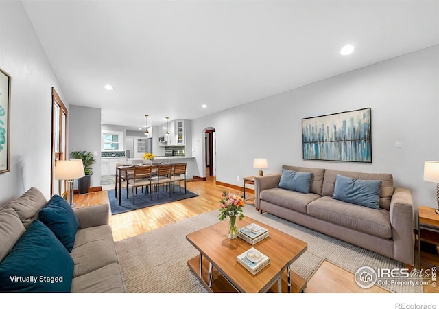 living room featuring recessed lighting, light wood-style flooring, and baseboards