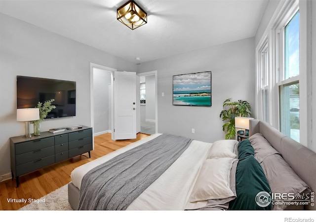 bedroom featuring wood finished floors and baseboards