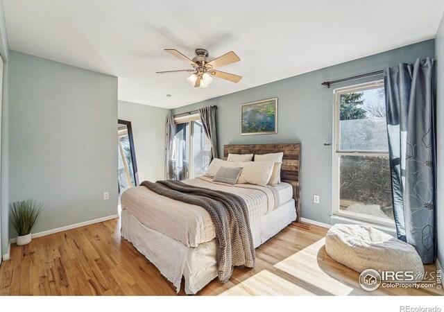 bedroom featuring ceiling fan, baseboards, and wood finished floors