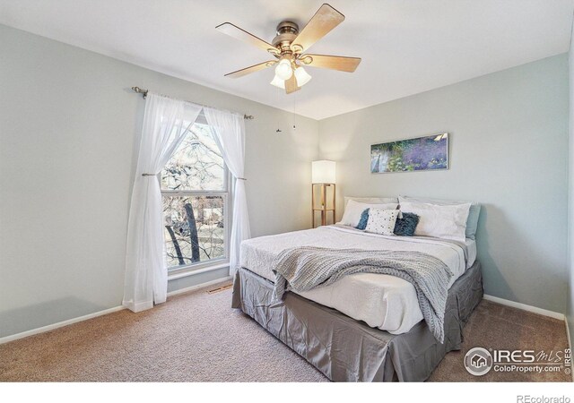 bedroom featuring ceiling fan, baseboards, and carpet