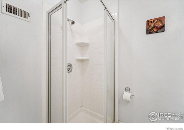 bathroom with visible vents and a stall shower