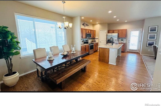 dining space featuring recessed lighting, light wood-style flooring, baseboards, and an inviting chandelier