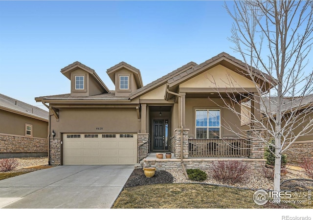 craftsman-style home featuring stucco siding, driveway, stone siding, a porch, and a garage