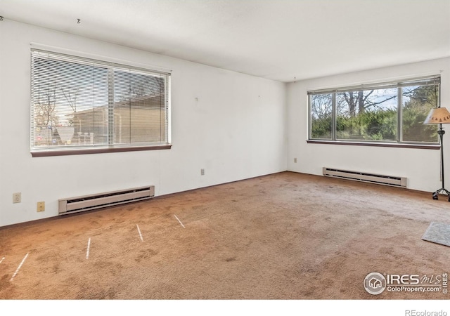 spare room with a baseboard heating unit and carpet floors