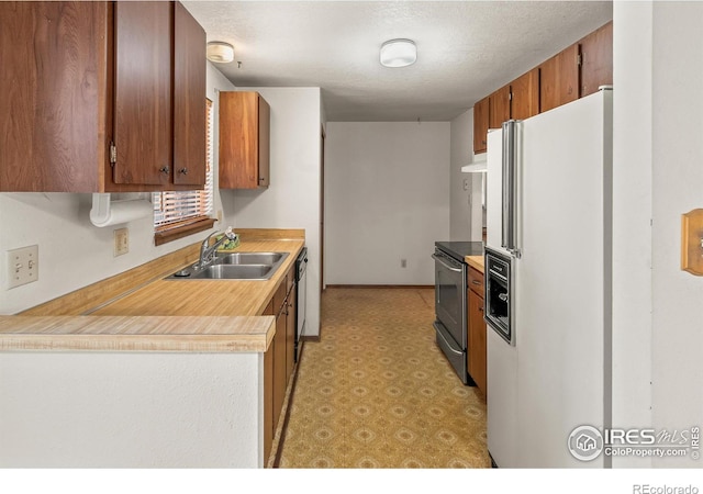 kitchen with a sink, white fridge with ice dispenser, light countertops, stainless steel electric range oven, and light floors