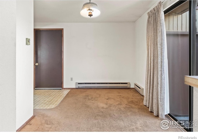 empty room with a baseboard heating unit and carpet floors