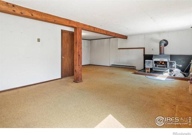 finished below grade area featuring a baseboard heating unit, a wood stove, carpet, and baseboards