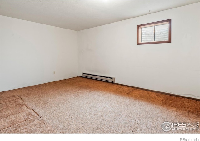 carpeted spare room featuring a baseboard heating unit