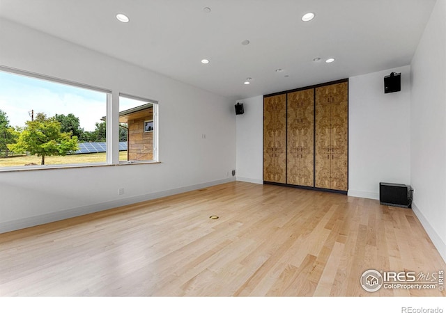 spare room featuring recessed lighting, light wood-style floors, and baseboards