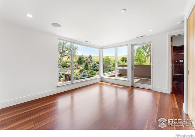 spare room with visible vents, recessed lighting, wood finished floors, and baseboards