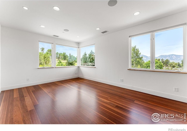 unfurnished room featuring visible vents, recessed lighting, baseboards, and wood finished floors