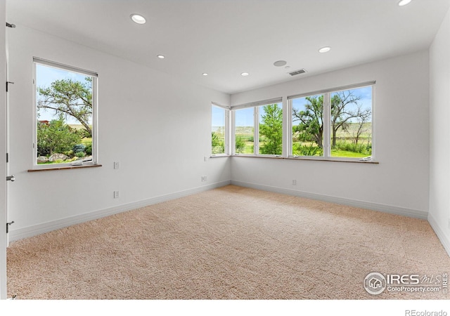 carpeted empty room with recessed lighting, visible vents, and baseboards