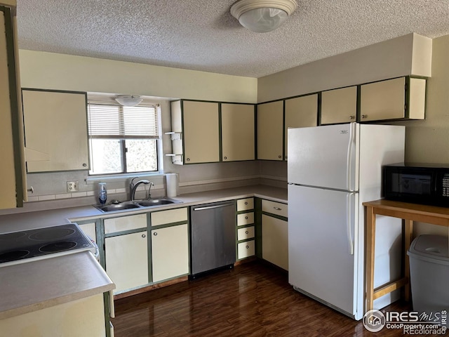 kitchen with black microwave, dishwasher, electric range oven, freestanding refrigerator, and a sink