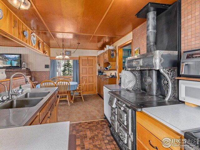 177 Bill Waite Rd, Allenspark, CO 80510 - kitchen featuring a sink, a chandelier, brown cabinetry, and brick patterned floors
