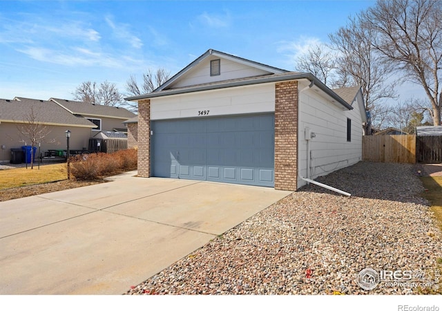 garage with driveway and fence