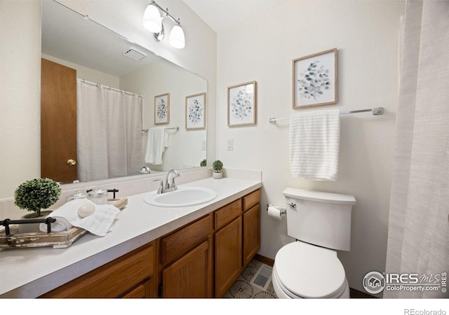 bathroom featuring visible vents, toilet, vanity, and a shower with curtain