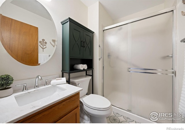 bathroom with a stall shower, toilet, and vanity