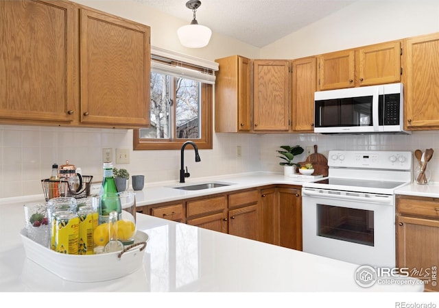 kitchen featuring light countertops, lofted ceiling, decorative backsplash, white appliances, and a sink