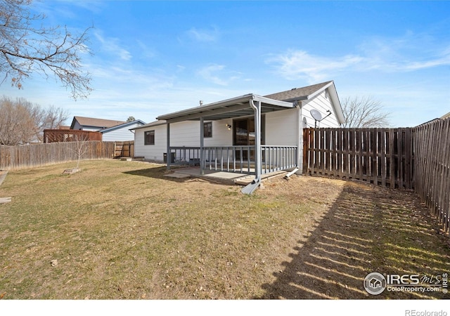 rear view of house featuring a lawn, a fenced backyard, and a patio area