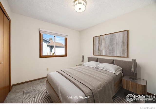 carpeted bedroom featuring a closet, baseboards, and a textured ceiling