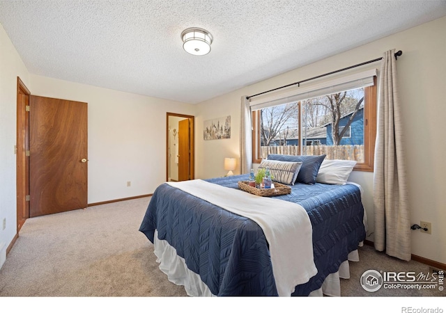 bedroom featuring carpet flooring, baseboards, and a textured ceiling