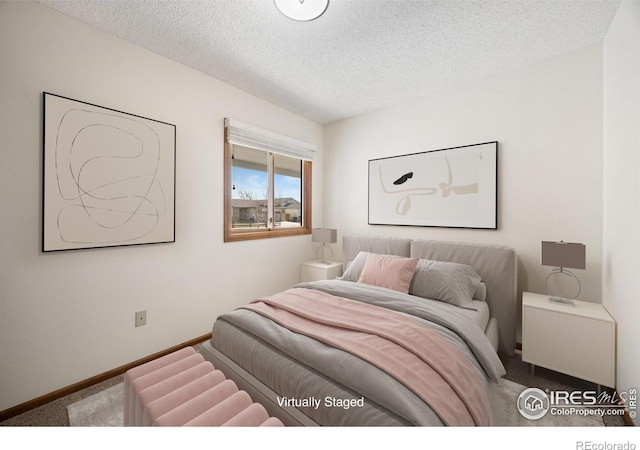 bedroom with carpet flooring, a textured ceiling, and baseboards