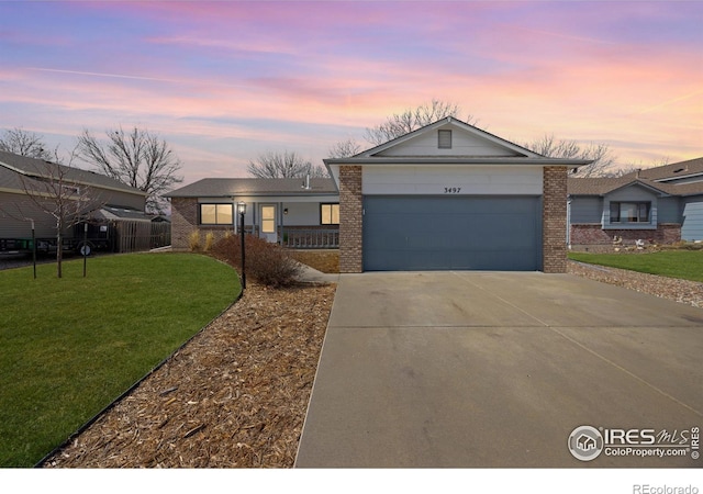 ranch-style house featuring a front yard, an attached garage, brick siding, and driveway